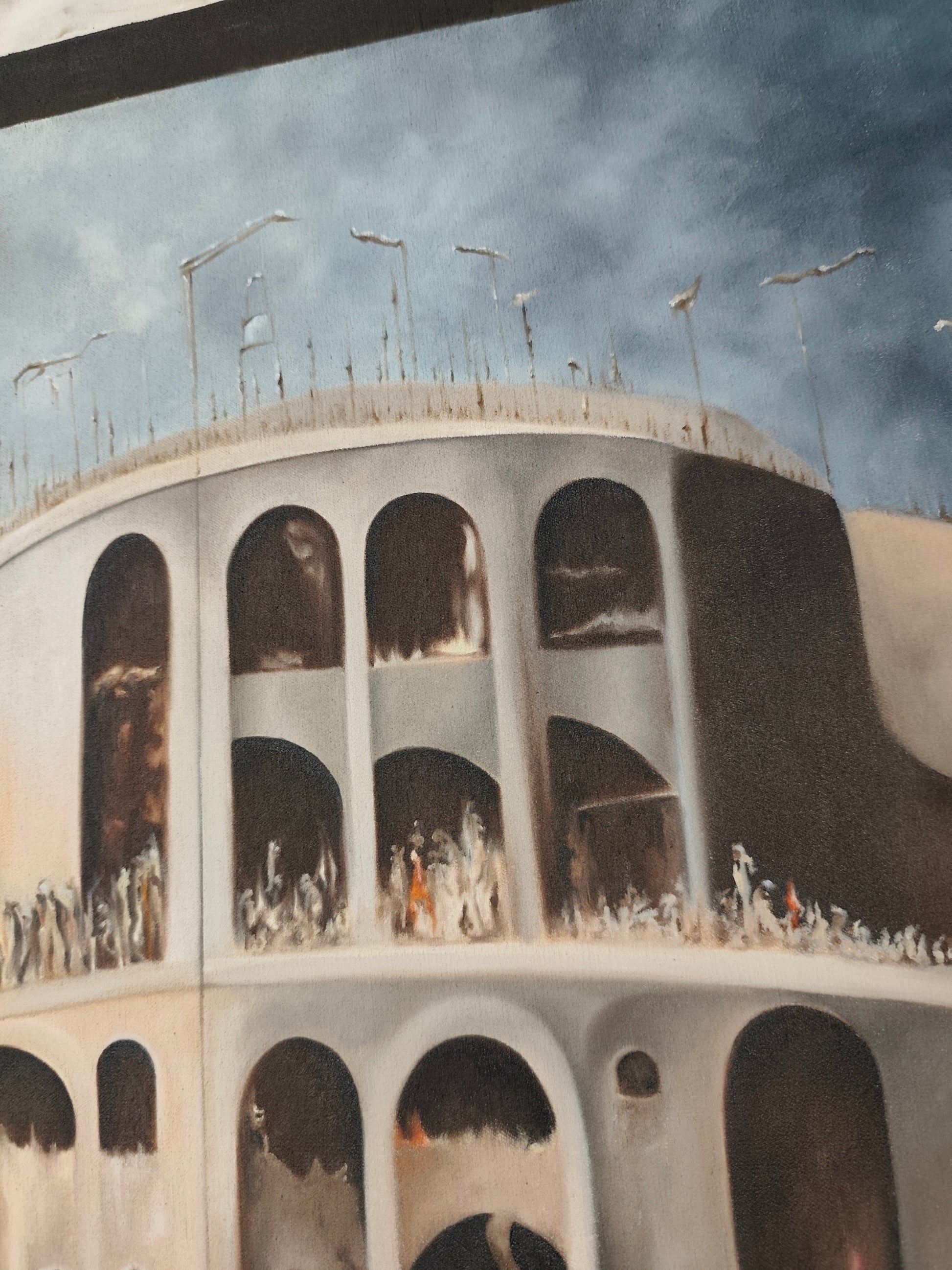 Detail of Why 12? by Melina Ghaemi - the rooftop of the rock-cut city, thin poles and lamp-like forms along the rim, arched niches holding small figures in the tiers beneath.