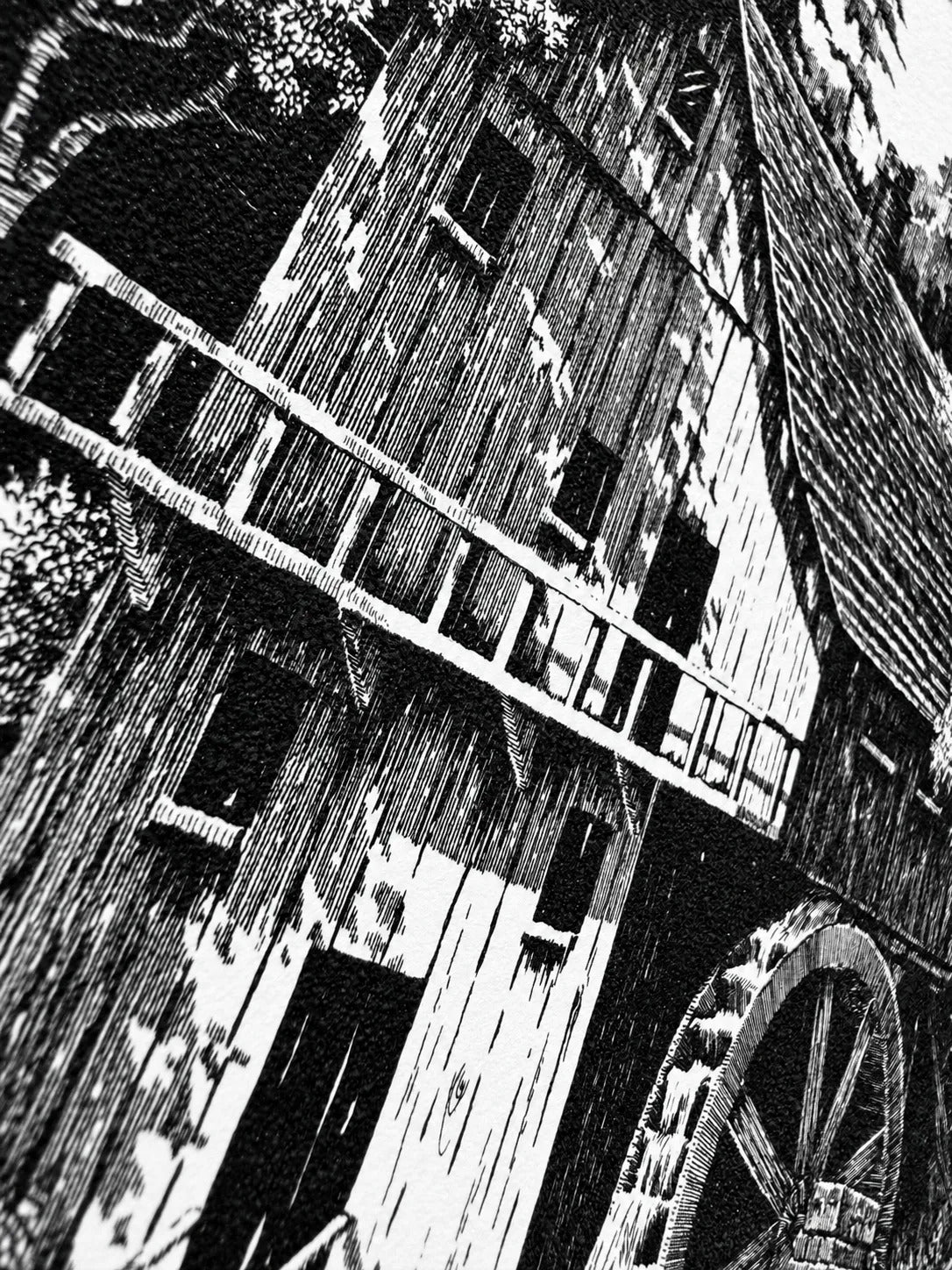 Angled close-up of the mill's timber facade and balcony, showing the fine parallel lines and the texture of the paper