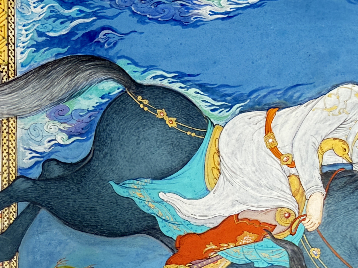 Detail of Siyavash Passing Through the Fire by Kamal al-Din Ghotb - the dark horse at full gallop with streaming tail and jewelled gold harness, a turquoise saddlecloth painted with gold arabesque, against lapis sky and blue-and-white cloud bands