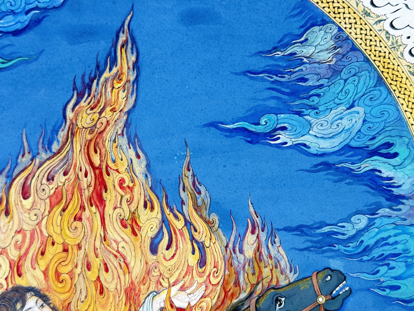 Detail of Siyavash Passing Through the Fire by Kamal al-Din Ghotb - tall gold, crimson and violet flame tongues rising against a lapis-blue sky worked with white and turquoise cloud scrolls, beside the gold knotwork border of the illuminated arch