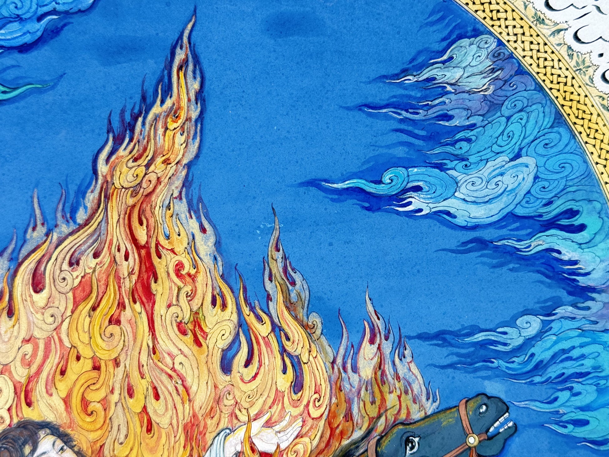 Detail of Siyavash Passing Through the Fire by Kamal al-Din Ghotb - tall gold, crimson and violet flame tongues rising against a lapis-blue sky worked with white and turquoise cloud scrolls, beside the gold knotwork border of the illuminated arch