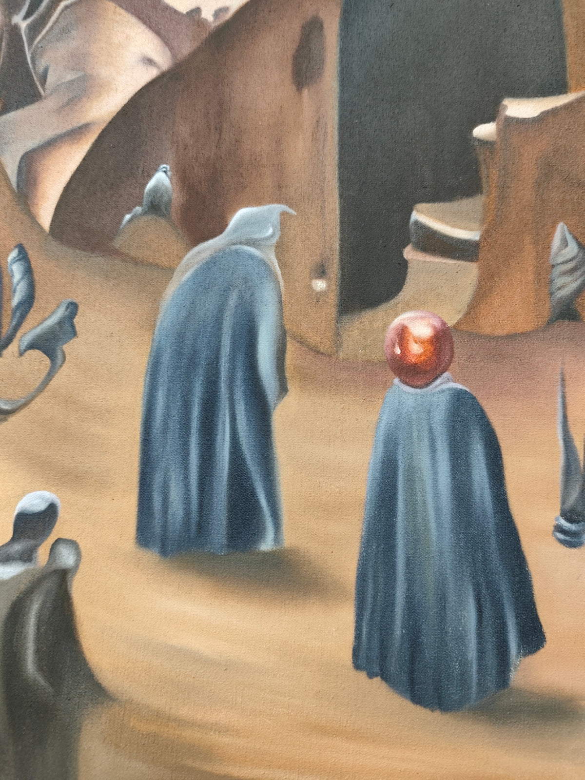 Detail of Why 12? by Melina Ghaemi - two figures in slate-blue cloaks crossing pale sand, one with a glossy red-orange sphere in place of a head.
