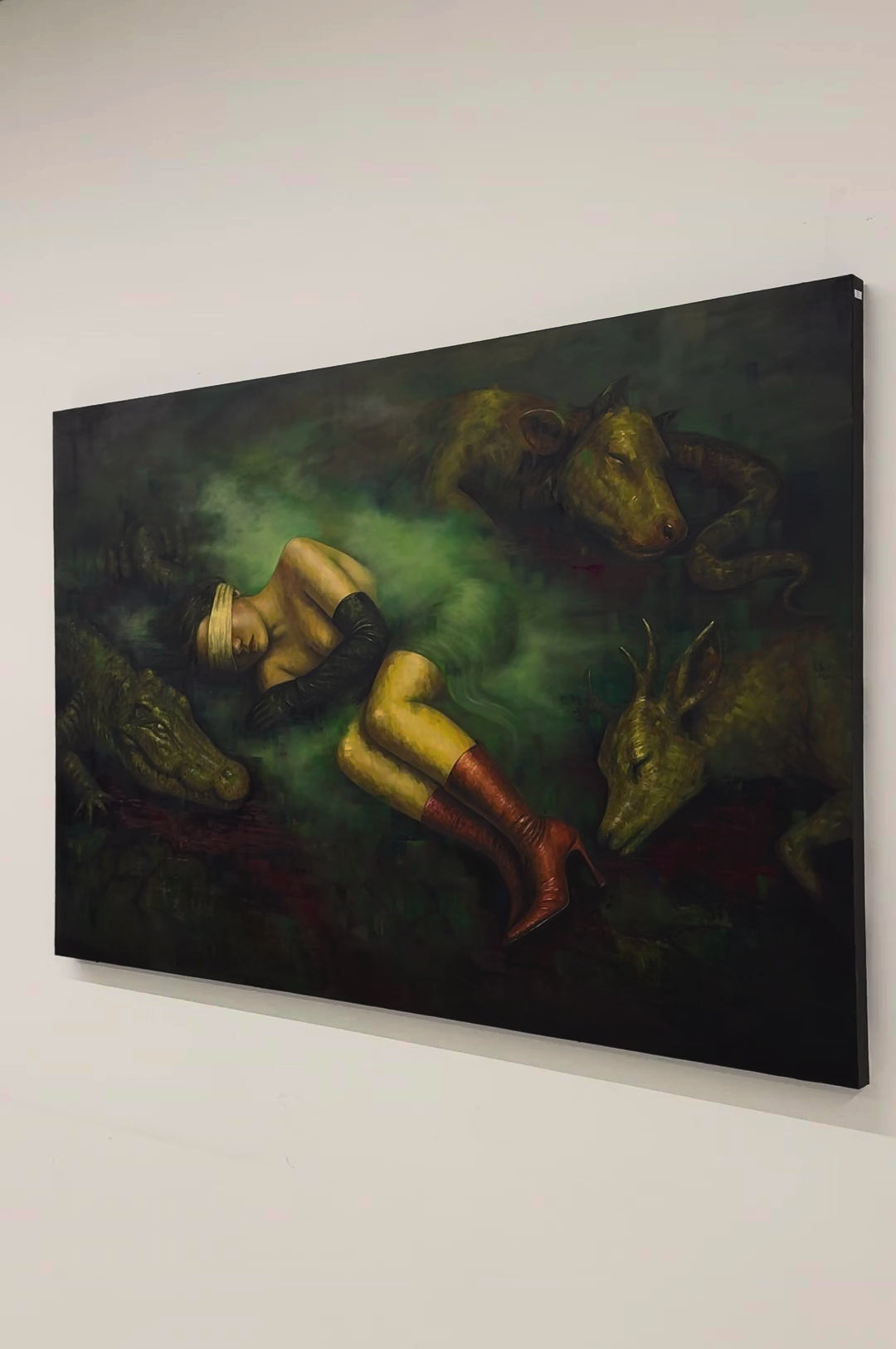 Video of Second Skin by Phaedra on a white wall, moving in from the side toward the sleeping woman and the crocodile