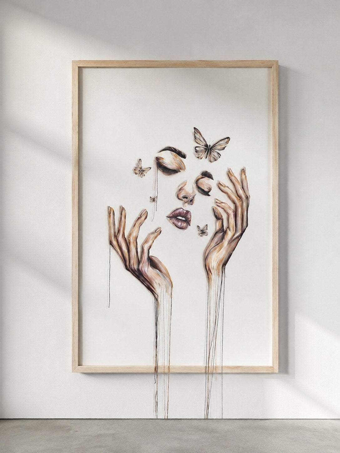 Threads of Becoming by Mahdiye in a light wood frame on a white wall in soft daylight, hand-stitched threads hanging below the frame